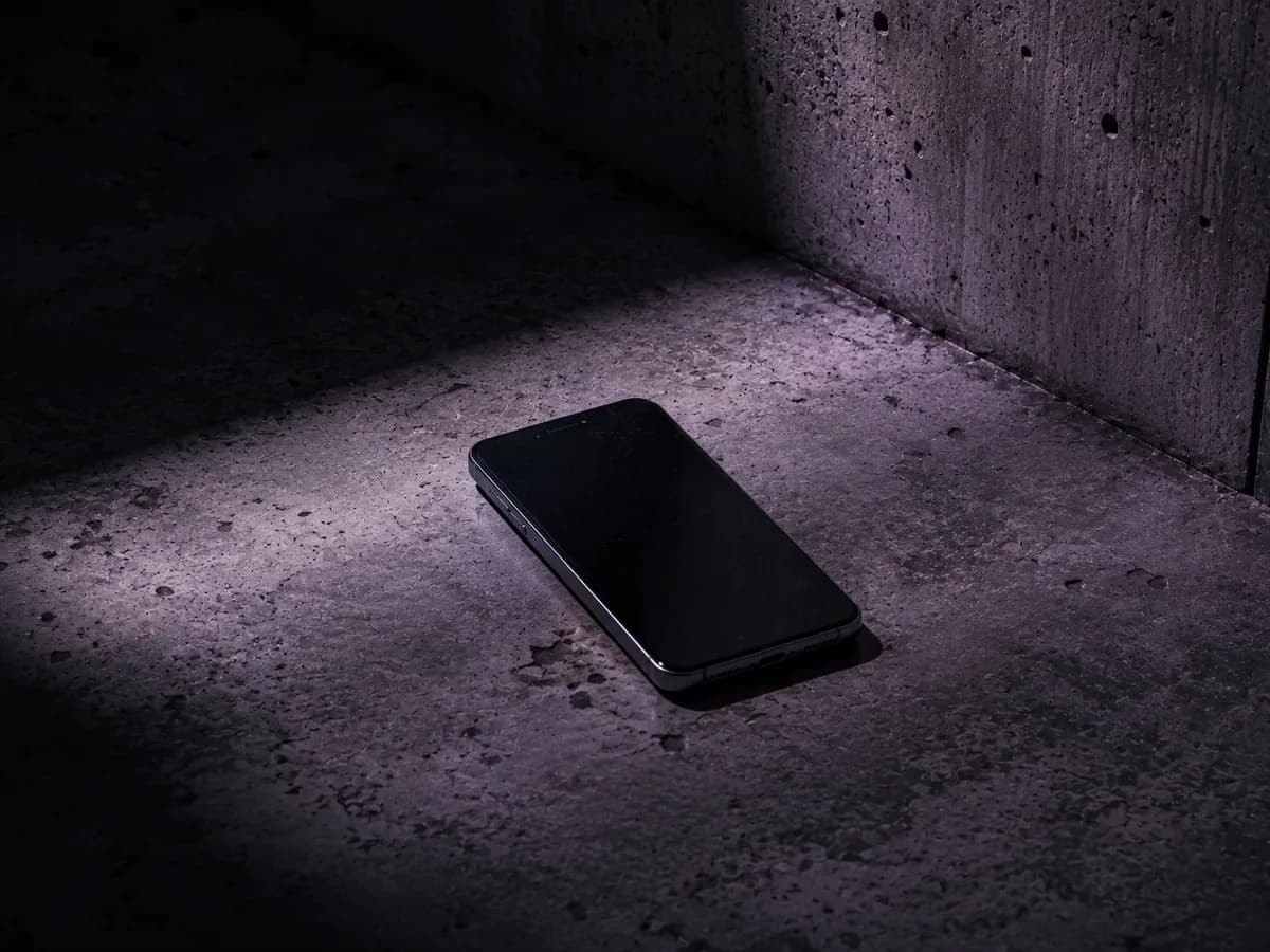 A phone lying on a concrete floor in dim light, illustrative image for the article